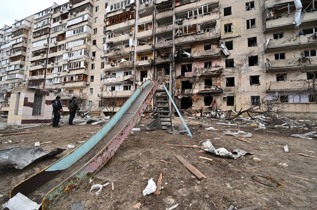 25 de fevereiro - Policiais observam destruição em prédio residencial em Koshytsa Street, um subúrbio da capital ucraniana Kiev — Foto: Genya Savilov/AFP