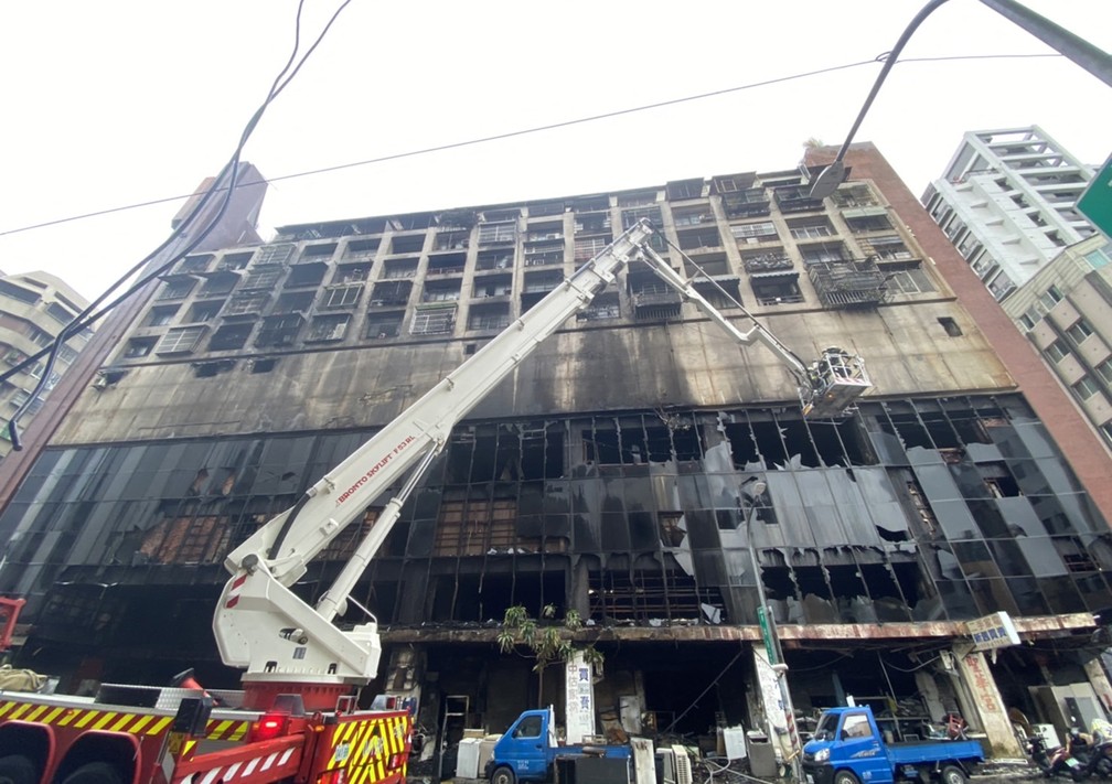 Equipes de emergência trabalham em prédio que pegou fogo na cidade de Kaohsiung, no sul de Taiwan, e deixou dezenas de mortos e feridos em 14 de outubro de 2021 — Foto: CNA (Agência Central de Notícias de Taiwan) via AFP
