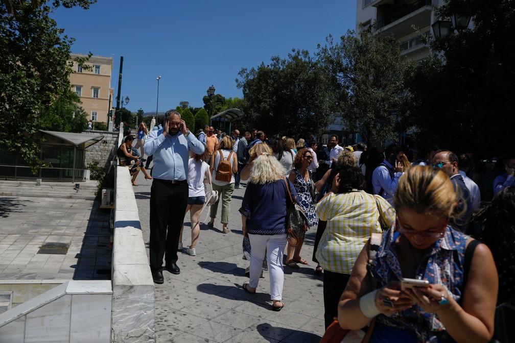 Pessoas saem às ruas após tremor atingir Atenas, na Grécia, nesta sexta-feira (19)   — Foto: Petros Giannakouris/AP