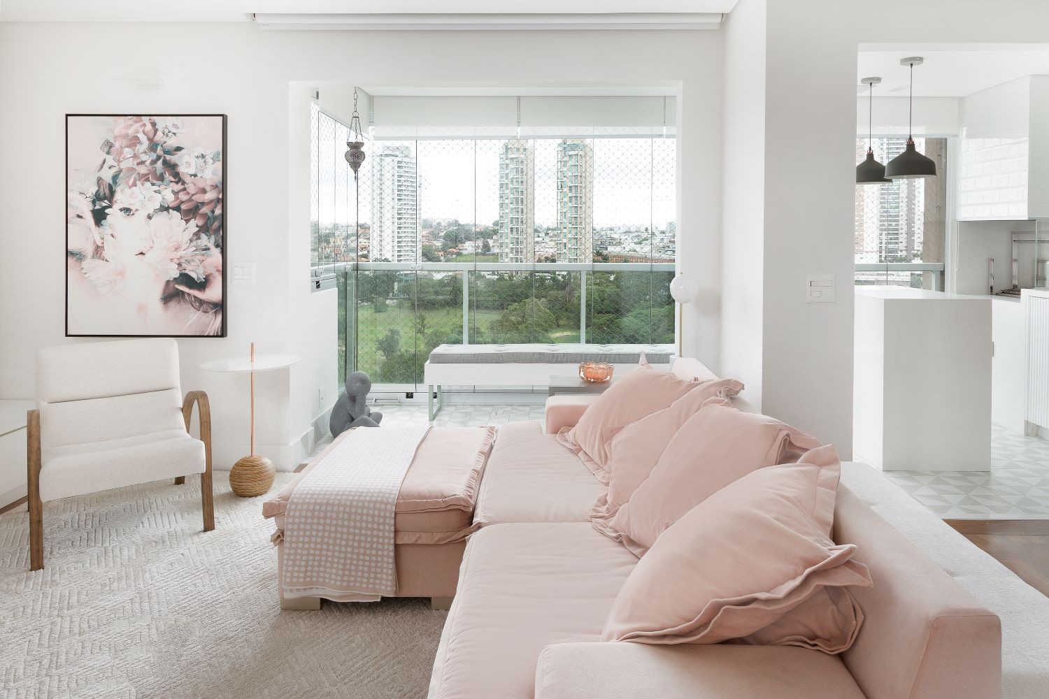 SALA DE ESTAR | Na sala, o sofá de veludo rosa traz o ponto focal de cor para o ambiente. Aqui, os móveis e abajur redondo são da Sierra Alphaville, quadros da Urban Arts e mesas de apoio do Design da Vila. Tapete é da Marrei (Foto: Divulgação / Júlia Ribeiro)