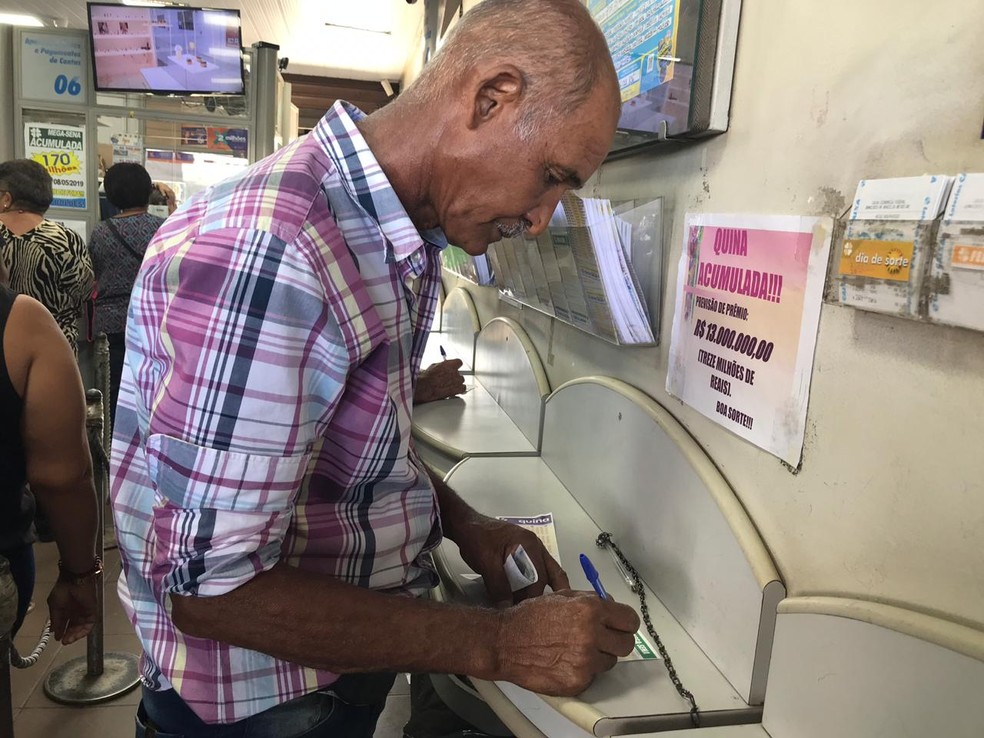 O aposentado João Rodrigues da Silva preenche o bilhete da Mega-Sena, em Brasília — Foto: Larissa Cunha / G1