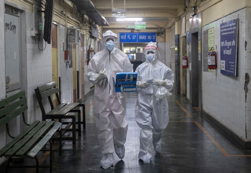 Profissionais de saúde utilizando equipamentos de proteção individual (EPI) passam por uma enfermaria para pacientes contaminados com Covid-19 no hospital Lok Nayak Jai Prakash em Nova Delhi, na Índia — Foto: Danish Siddiqui/Reuters