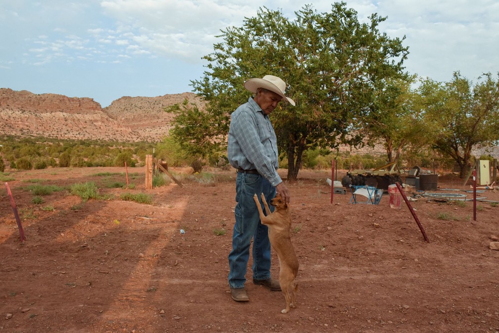 Leonard brinca com um cachorro no quintal de sua casa — Foto: Stephanie Keith/Reuters