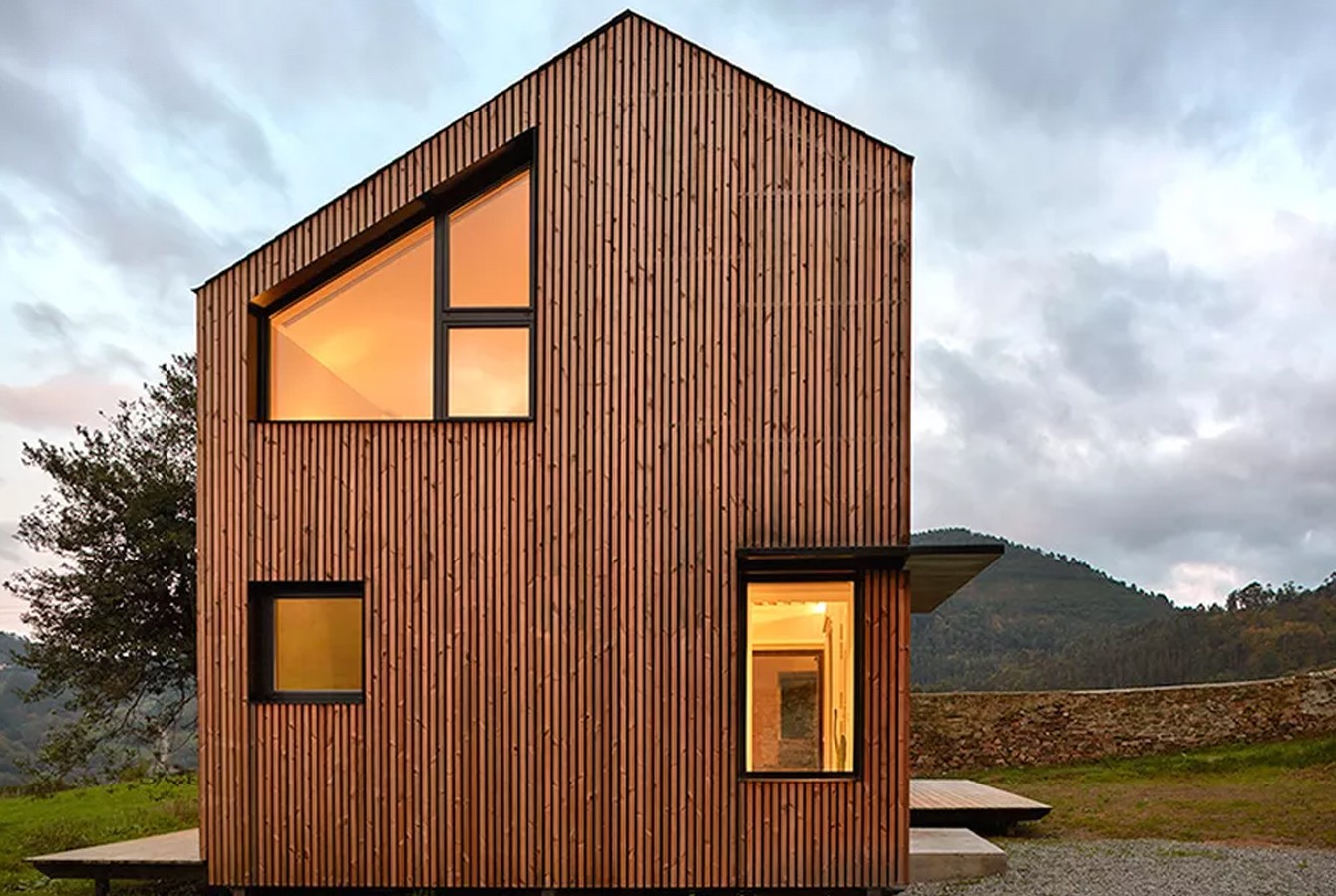 Fachada da casa é feita com ripas de madeira instaladas verticalmente (Foto: Mariela Apollonio/ Reprodução)