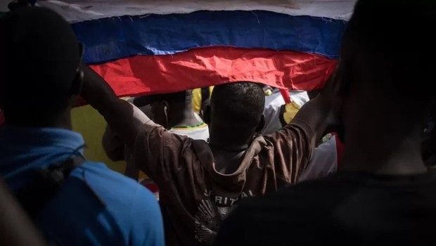 Manifestante com bandeira russa durante ato comemorando anúncio da França de retirada de suas tropas do Mali (Foto: Getty Images via BBC)