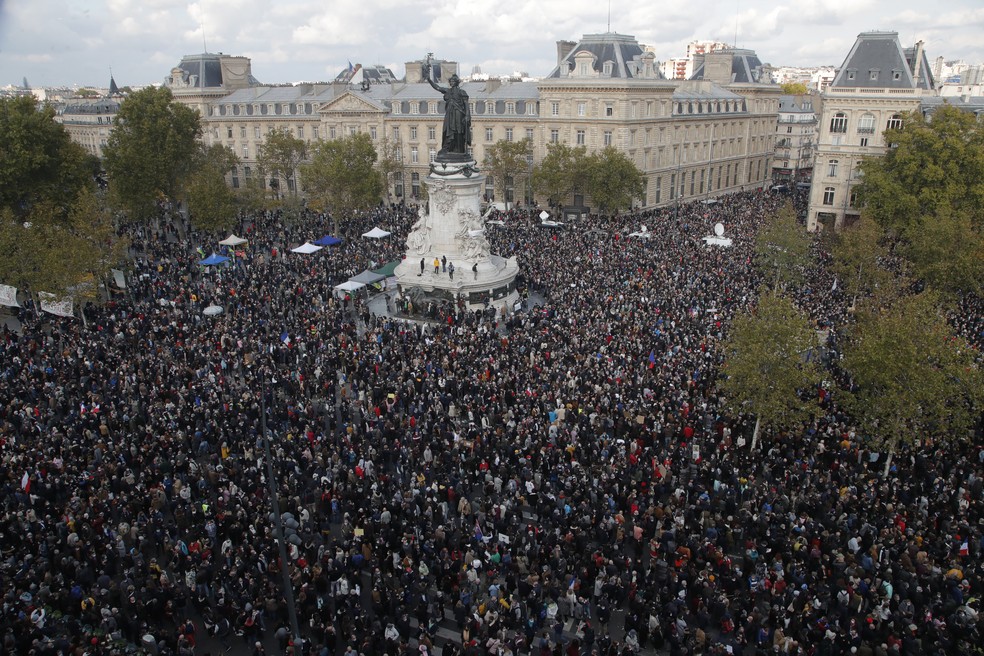 Manifestantes se reúnem na Praça da República, em Paris, neste domingo (18) para marchar em homenagem ao professor de história decapitado em um ataque extremista — Foto: Michel Euler/AP