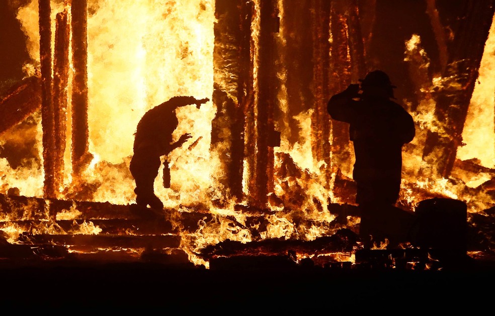 Fotógrafo da agência Reuters registrou o momento em que Aaron Mitchell adentra as chamas no festival Burning Man. A legenda original usa o termo 'cair' para descrever a cena, sem deixar claro se houve intenção (Foto: Jim Bourg/Reuters)