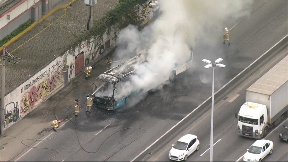Bombeiros tentam controlar fogo em ônibus na manhã desta terça-feira (2), no Rio de Janeiro. (Foto: Reprodução / Tv Globo)