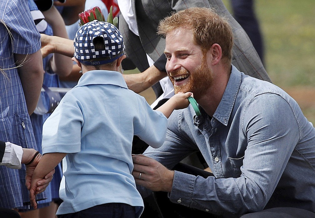 Menino de 5 anos brinca com a barba do príncipe Harry em Dubbo, na Asutrália — Foto: Phil Noble/Pool via AP
