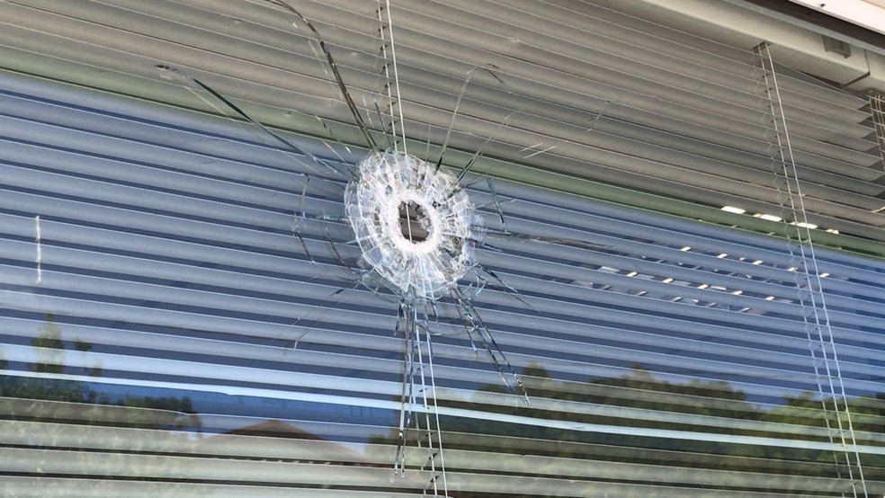 Um dos tiros atingiu vidro de agência — Foto: Altamir Oliveira/Rádio Estação