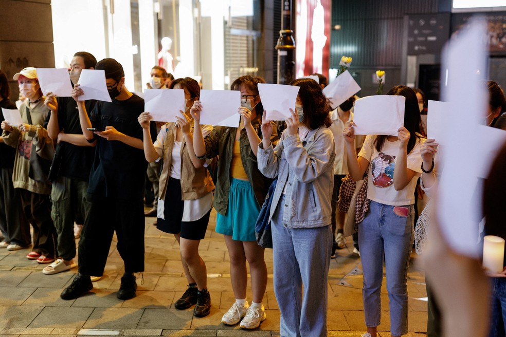 Manifestante segurando um pedaço de papel em branco na China — Foto: Tyrone Siu/Reuters