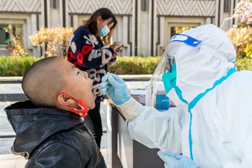 Criança é testada para o coronavírus em Ganzhou, no estado de Zhangye, na China — Foto: STR / AFP