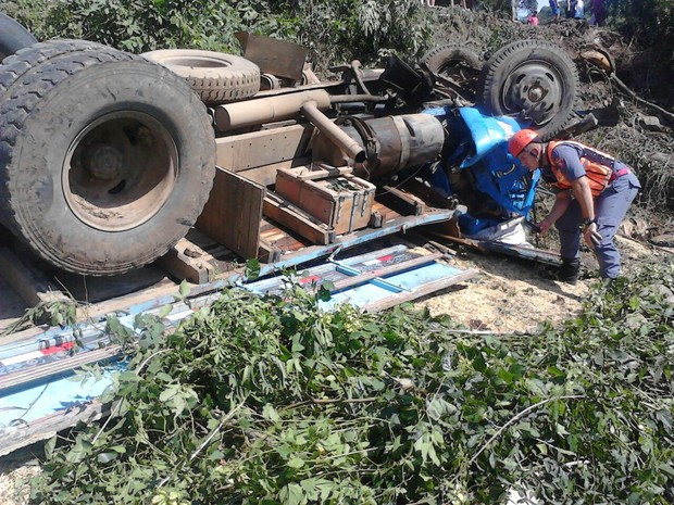 Após bater em árvore, caminhão capotou e motorista ficou preso nas ferragens (Foto: Corpo de Bombeiros/Divulgação)