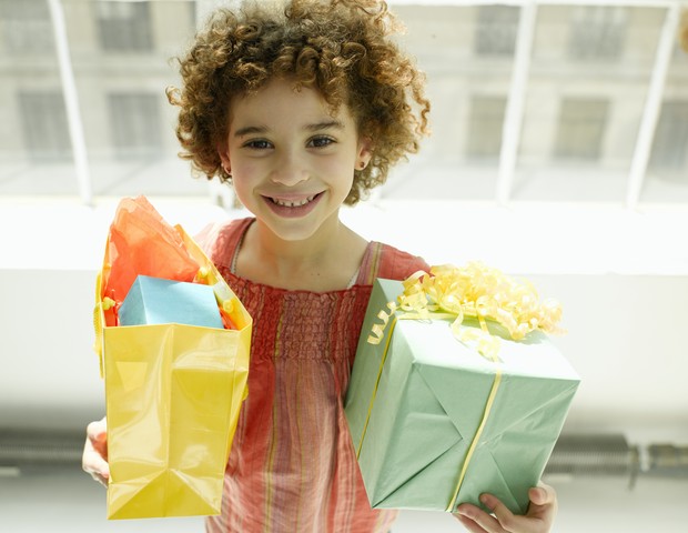 Criança segurando presentes  (Foto: Getty Images)