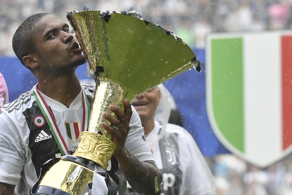 Douglas Costa assinou contrato para ficar até 2022 na Juventus (Foto: Marco BERTORELLO / AFP)