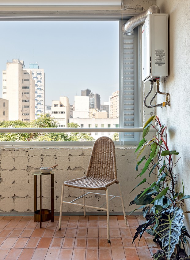 A cadeira e a mesa lateral de antiquário ficam junto do janelão colocado pelo arquiteto durante a reforma do antigo setor de serviços (Foto: Fran Parente / Divulgação)