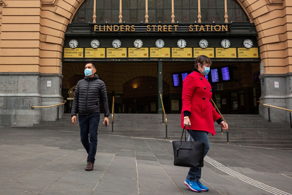 Pessoas usam máscara perto da estação Flinders Street, em Melbourne, na Austrália — Foto: AAP Image/Daniel Pockett via Reuters