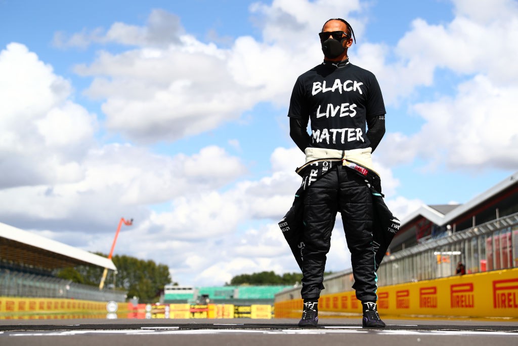 NORTHAMPTON, ENGLAND - AUGUST 02: Lewis Hamilton of Great Britain and Mercedes GP wears a t-shirt displaying the message 'Black Lives Matter' as he stands at the front of the grid in support of the movement to end racism before the Formula One British Gra (Foto: Formula 1 via Getty Images)