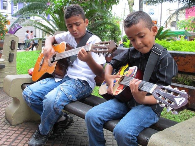 Marcos e Maycon tocando e cantando em praça em São Vicente, SP (Foto: Mariane Rossi/G1)