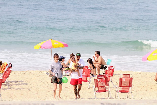 Marcelo D2 e a mulher, Luiza Machado, curtiram praia com a pequena Maria Luiza (Foto: Dan Delmiro / AGNews)