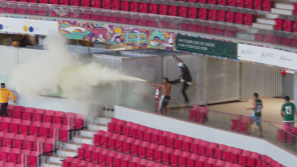 Homem usa extintor de incêndio durante confusão entre Brasiliense e Gama, no DF — Foto: TV Globo/Reprodução
