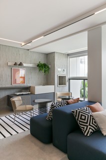 Na sala de estar projetada pela arquiteta Thaisa Bohrer, o sofá em ilha possibilita o encontro e convida às conversas. Há também uma poltrona, que cria um canto de leitura bem acolhedor