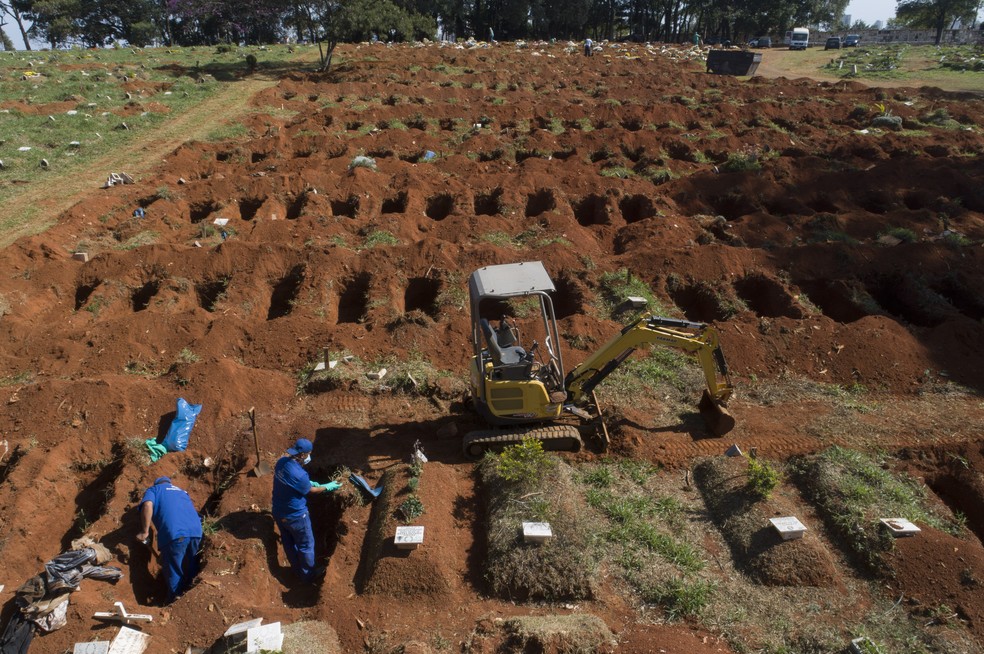 Coveiros fazem exumação de corpos enterrados há 3 anos no cemitério da Vila Formosa, em São Paulo, durante a pandemia do novo coronavírus no Brasil — Foto: Andre Penner/AP