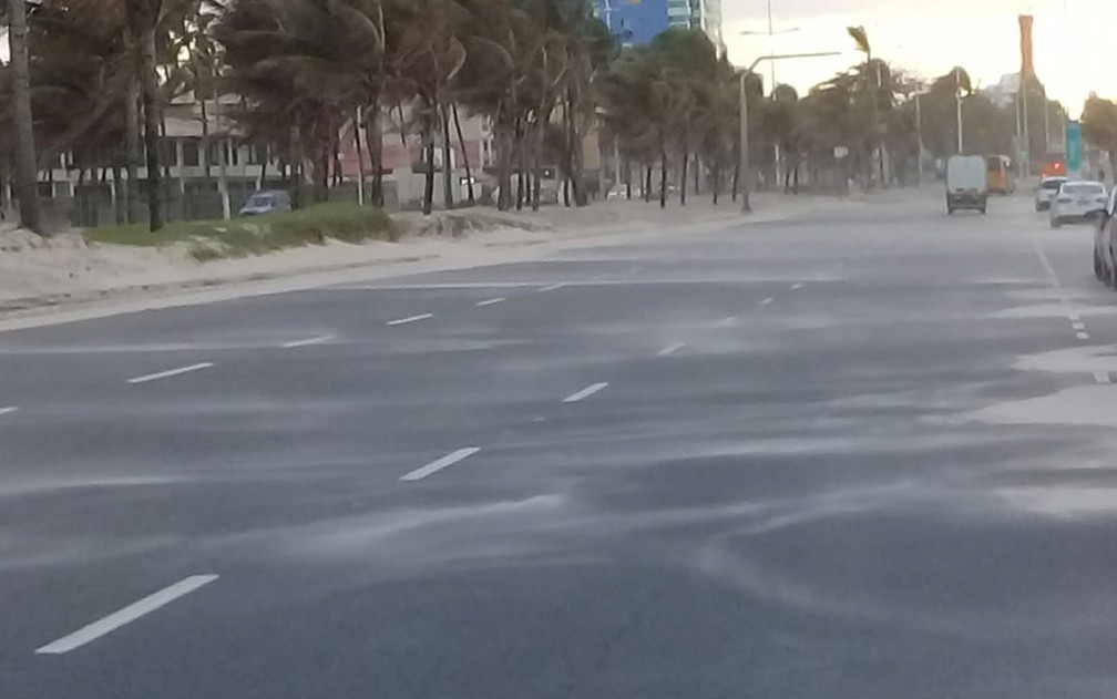Ventos fortes arrastaram areia da praia para calçadão e pista de veículos no bairro de Piatã, em Salvador  — Foto: Cid Vaz/TV Bahia