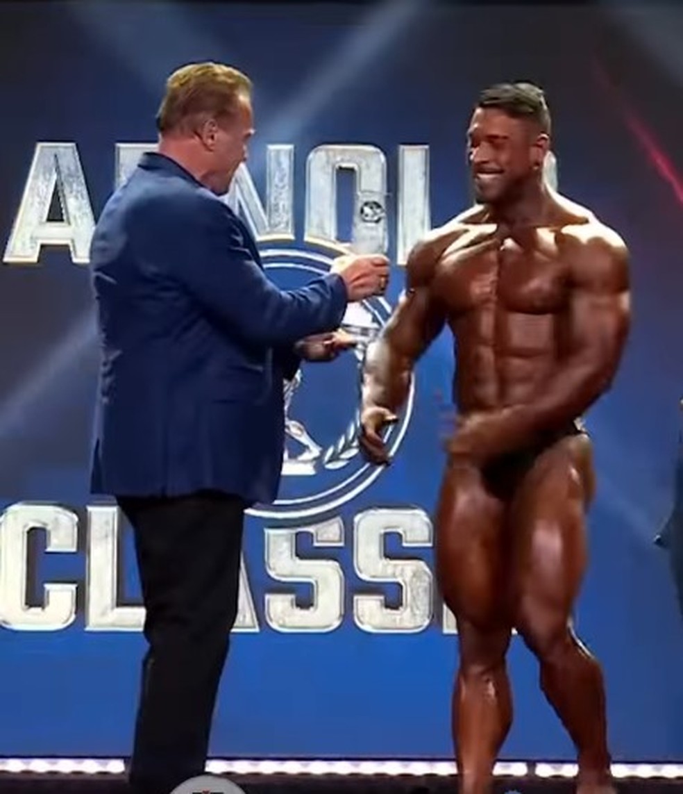 Ramon Queiroz, o Dino, recebe troféu de campeão do Arnold Sports de Schwarzenegger — Foto: Reprodução/Max Titanium