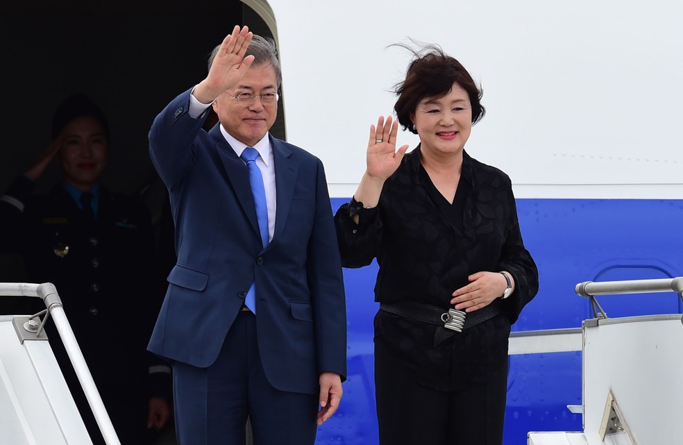 O presidente da Coreia do Sul, Moon Jae-in, e sua mulher Kim Jung-sook,  acenam ao chegar a Buenos Aires nesta quinta-feira (29). — Foto: Martin Bernetti/AFP