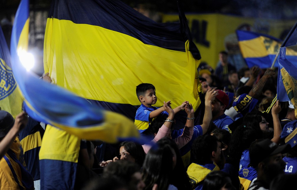 Criança no meio da festa com bandeiras dos torcedores do Boca Juniors antes da viagem do time para a final da Taça Libertadores — Foto: REUTERS/Stringer
