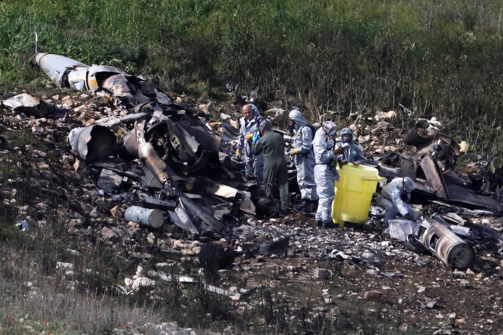 Forças de segurança israelenses examinam restos de um caça F-16 perto da vila de Harduf, em Israel  (Foto: Ronen Zvulun/Reuters)