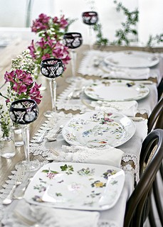 Pratos com estampas similares e formatos diferentes compõem uma mesa romântica, com um toque de modernidade