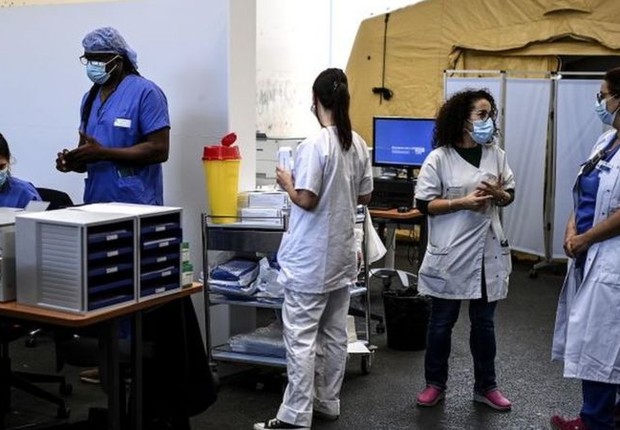 BBC: Profissionais de saúde durante a pandemia de coronavírus em Paris; imigrantes que trabalharam na linha de frente vão receber cidadania com maior celeridade (Foto: GETTY IMAGES VIA BBC      )