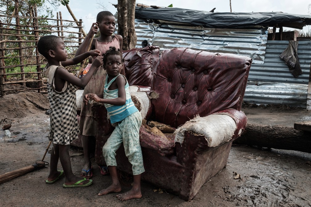 Crianças brincam em frente a uma casa destruída pelo ciclone Idai em Beira, Moçambique, nesta quarta (27) — Foto: Yasuyoshi Chiba/AFP