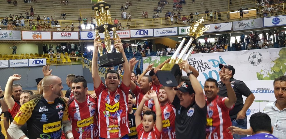 Jogadores de São Carlos levantam o troféu inédito para a cidade da Taça EPTV de Futsal Central — Foto: Heitor Esmeriz/Globo Esporte