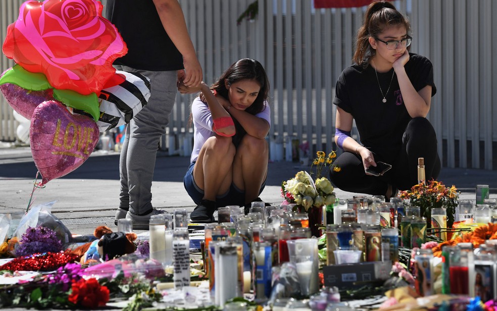 Briana Calderon e Cinthya Olbera rezam em memorial pelas vítimas na Las Vegas Strip em Las Vegas, Nevada na terça-feira (3) (Foto: Mark Ralston/AFP)