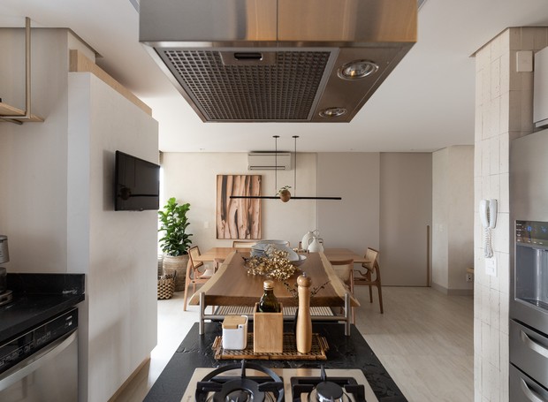 COZINHA INTEGRADA | A cozinha, que se integra ao living, recebeu uma ilha central incorporada a uma bancada para refeições rápidas (Foto: marc)