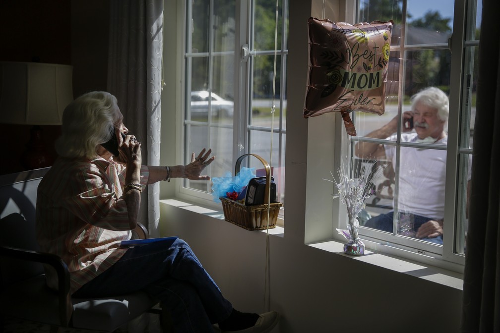 10 de maio - Mary Faye Cochran, 86, canta 'You Are My Sunshine' por telefone para seu filho Stacey Smith através de uma janela em comemoração ao Dia das Mães, em uma casa de repouso, em Smyrna, na Geórgia, nos EUA — Foto: Brynn Anderson/AP