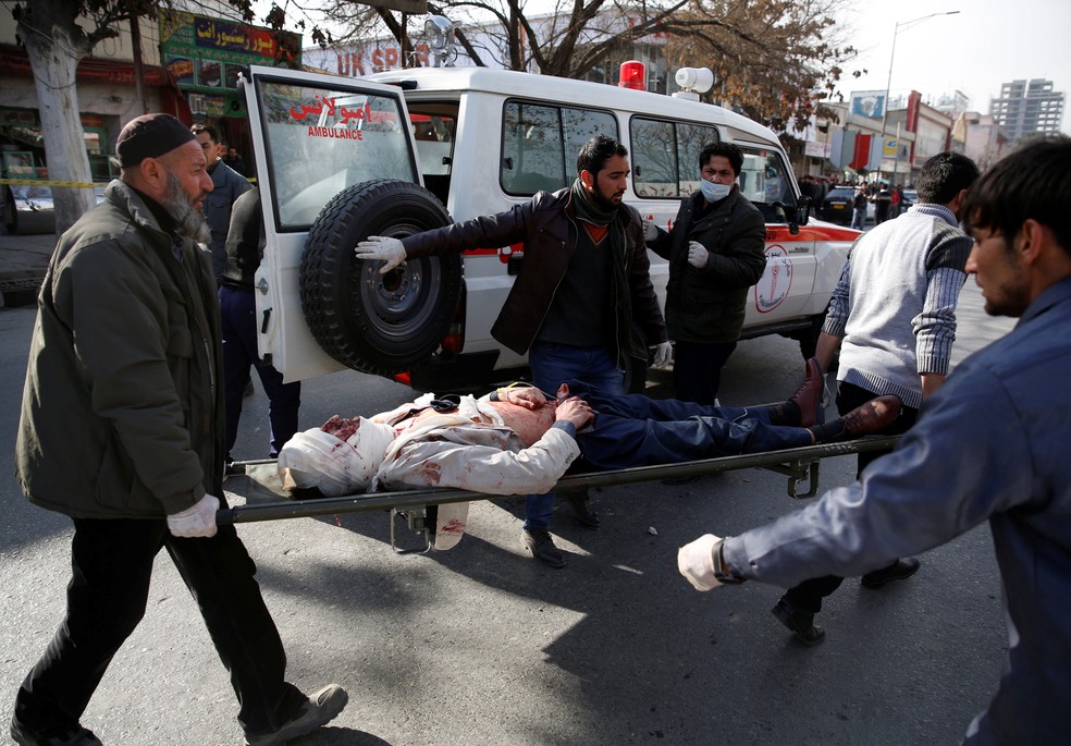 Homem ferido é resgatado após explosão de ambulância em Cabul, neste sábado (27)  (Foto: Mohammad Ismail/ Reuters)