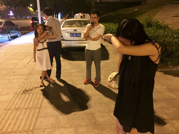 Pessoas na cidade chinesa Tianjin choram em rua próxima à explosão (Foto: REUTERS/Stringer)
