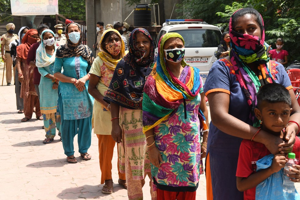 Moradores aguardam distribuição de alimentos em Amritsar, na Índia — Foto: Narinder Nanu/AFP