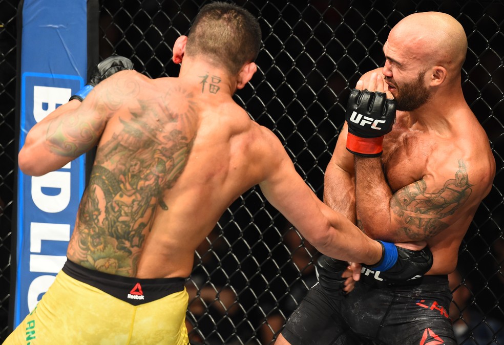 Robbie Lawler faz cara de dor ao receber golpe de Rafael dos Anjos na linha de cintura (Foto: Josh Hedges/Getty Images)