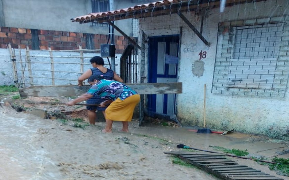 Moradores tentaram fazer contenções para evitar que o volume de água entrasse nas casas — Foto: Erinaldo Gonzaga