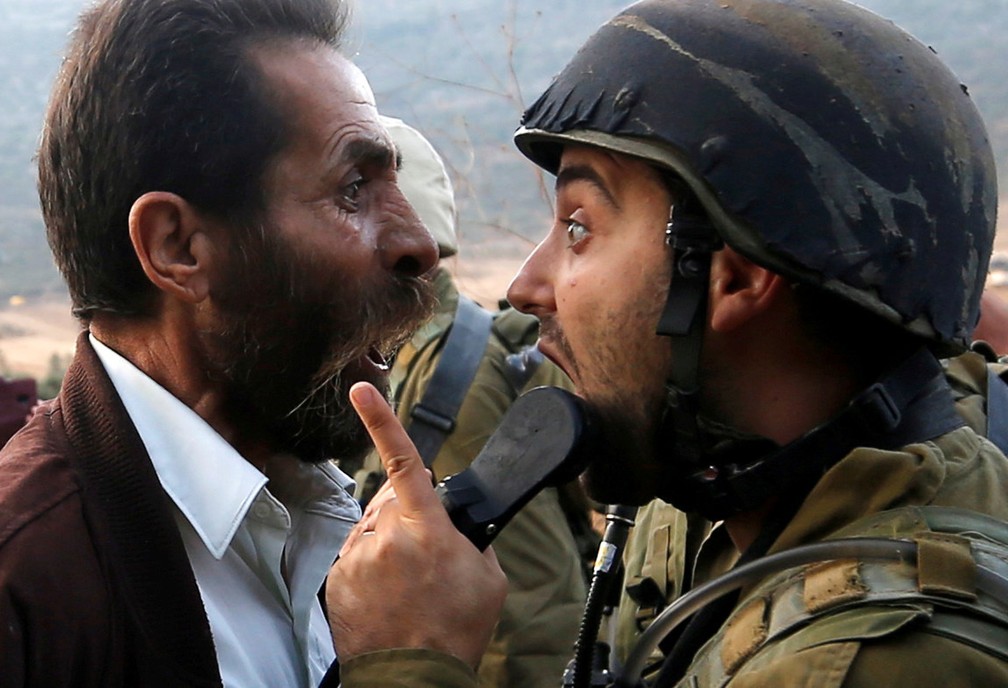 15 de outubro - Um palestino discute com um soldado israelense durante confrontos sobre uma ordem israelense de fechar uma escola palestina em Nablus, na CisjordÃ¢nia ocupada â€” Foto: Mohamad Torokman/Reuters