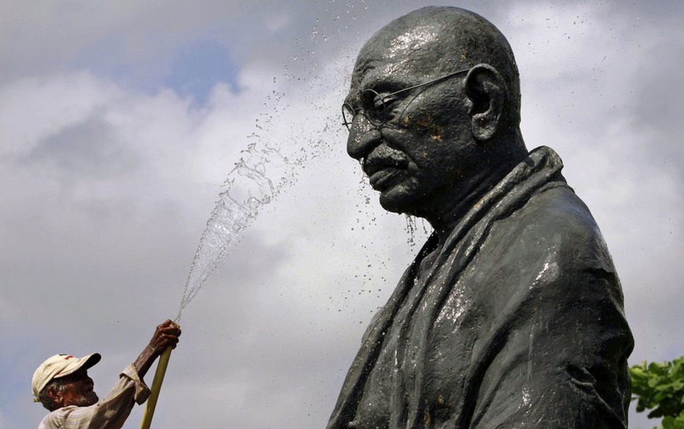 Funcionário do Gandhi Park molha uma estátua do líder indiano Mahatma Gandhi em Bhubaneswar, na Índia, à véspera do aniversário de 163 anos de seu nascimento. Ele morreu em 30 de janeiro de 1948, aos 78 anos. — Foto: Biswaranjan Rout/AP