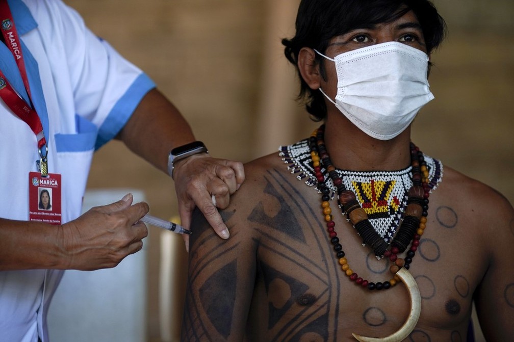 Homem indígena Guarani é vacinado com a CoronaVac na aldeia São Mata Verde Bonita, em Maricá (RJ), no dia 20 de janeiro.  — Foto: Mauro Pimentel / AFP