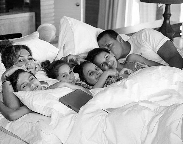 Jennifer Lopez e Alex Rodriguez em uma cama na companhia de seus filhos de relacionamentos prévios (Foto: Instagram)