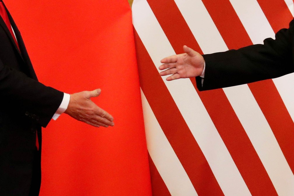 As mãos dos presidentes da China e dos EUA, Xi Jinping e Donald Trump, se estendem para cumprimento durante visita do americano a Pequim. Eles assinaram acordos comerciais no valor de US$ 253,4 bilhões, descritos como 'um milagre histórico' pelo lado chinês (Foto: Damir Sagolj/Reuters)