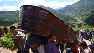 Familiares carregam caixão durante o enterro de pessoas que morreram em acidente envolvendo caminhonete que caiu de um penhasco na vila de Conacaste, município de Jocotan, Guatemala, matando 17 pessoas  — Foto: JOHAN ORDONEZ/AFP